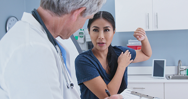 Woman with shoulder pain at doctor