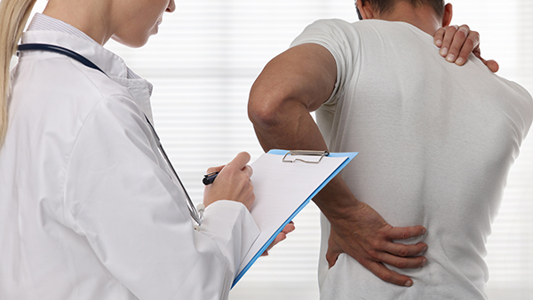 Doctor examining patient with back pain