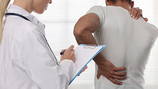 Doctor examining patient with back pain Doctor examining patient with back pain