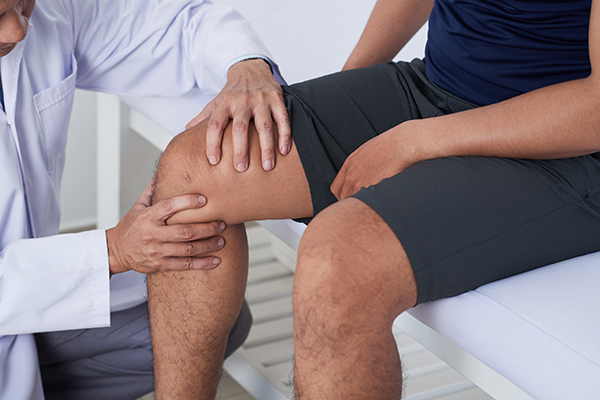 Doctor examining knee Doctor examining knee